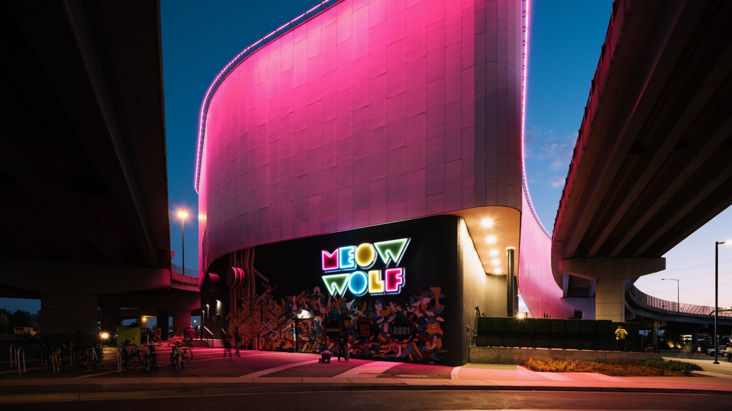 Building with neon sign reading 'Meow Wolf'